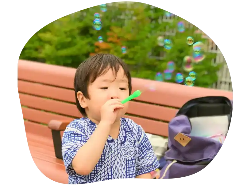 シャボン玉を吹きながら遊んでいる子ども