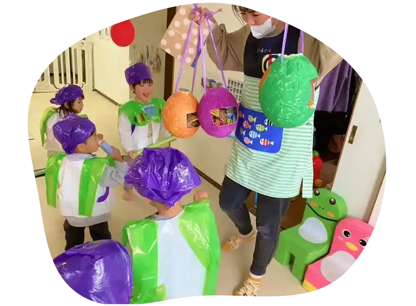 保育園で先生と一緒に遊んでいる子どもたち